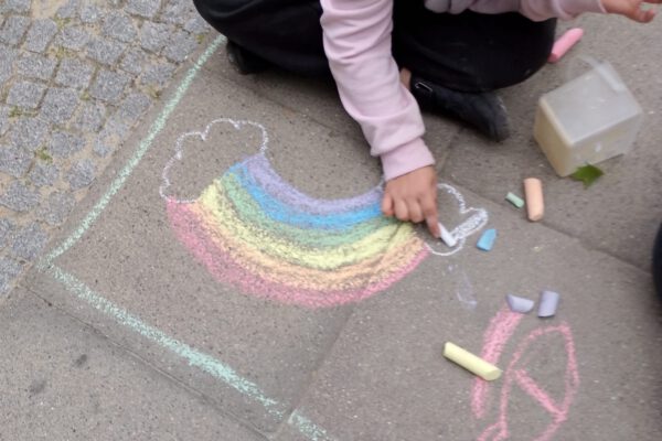 Ein Kind malt einen Regenbogen