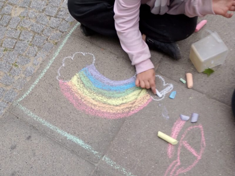 Ein Kind malt einen Regenbogen