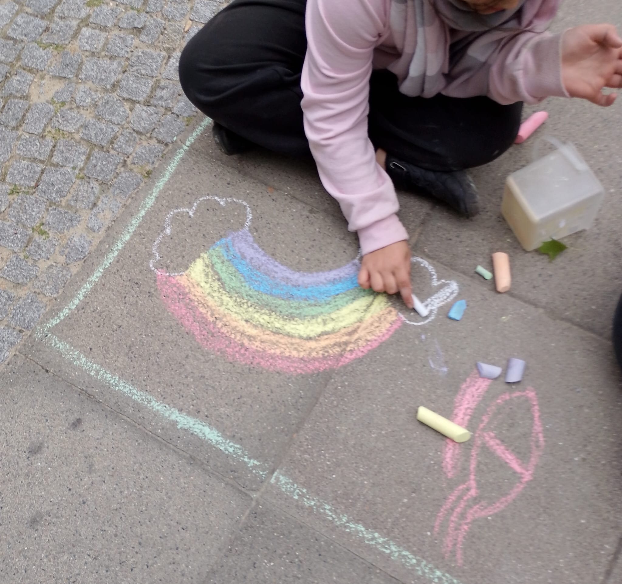 Ein Kind malt einen Regenbogen