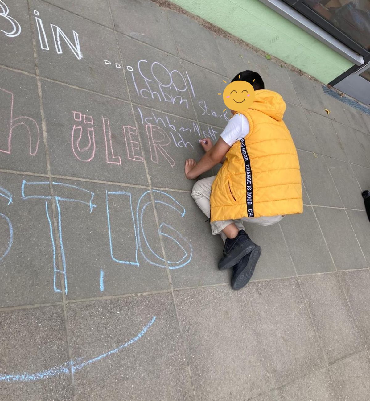 Ein junger Mensch malt das Kreidebild Ich bin